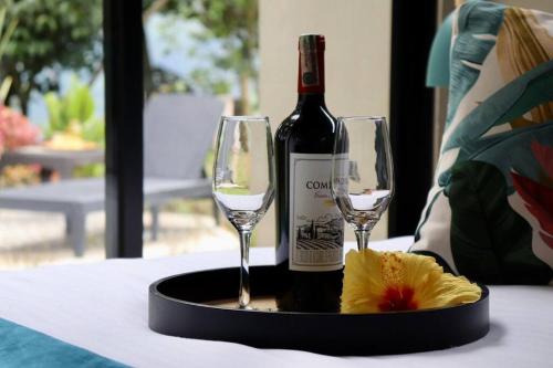 una bottiglia di vino e due bicchieri su un tavolo di Luxury Glamping - Tiny House al natural a La Vega