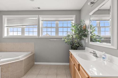 a bathroom with a tub and a sink and a tubermottermott at Beachview OC 4 in Ocean City