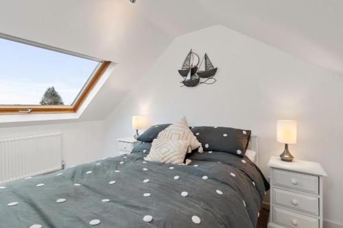 a bedroom with a bed and a window at Kittiwake - Short Walk to Beach and Village in Saundersfoot