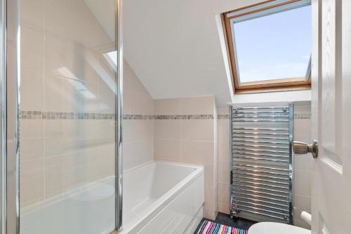 a bathroom with a bath tub and a toilet at Kittiwake - Short Walk to Beach and Village in Saundersfoot