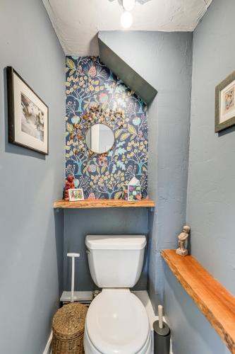 a bathroom with a toilet and a mirror on the wall at Lambertville Retreat - Walk to Shopping and Dining! in Lambertville