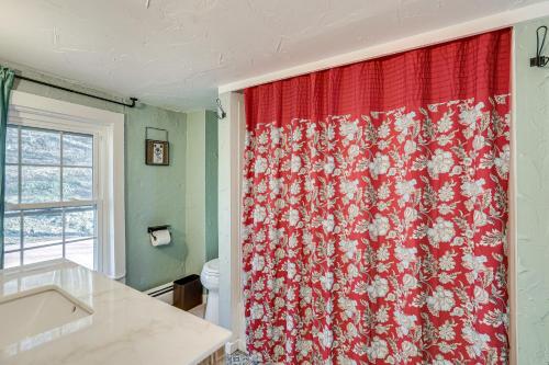 a bathroom with a red shower curtain with a toilet at Lambertville Retreat - Walk to Shopping and Dining! in Lambertville