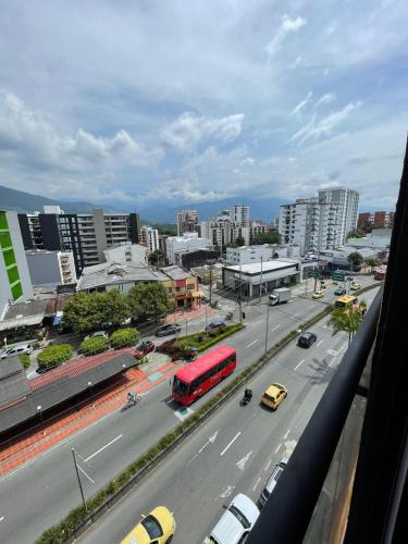 a city with a red bus on a street with cars at APTO EN NORTE DE ARMENIA in Armenia