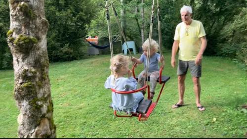 two children playing on a swing in a yard at Moulin de la Fayolle in Blot-lʼÉglise
