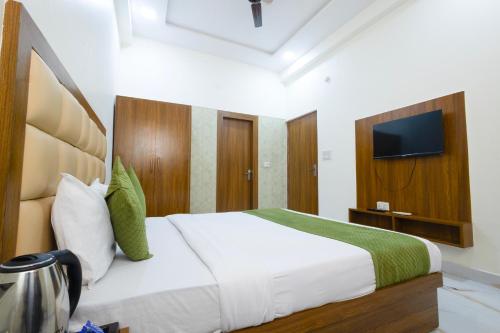 een slaapkamer met een bed en een televisie aan de muur bij Hotel Lime Tree by Madhav in Mathura