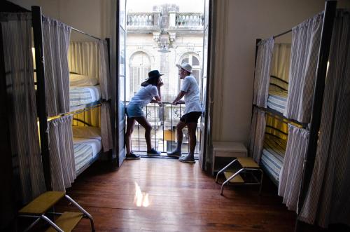 two people standing in a room with bunk beds at BA Stop Hotel House in Buenos Aires