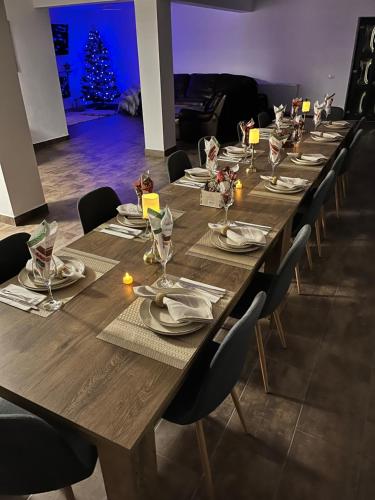 a long table with chairs and a christmas tree in the background at Transylvania House in Moieciu de Jos