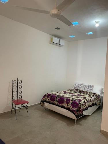 a bedroom with a bed and a red chair at Casa bugambilias in Cabo San Lucas