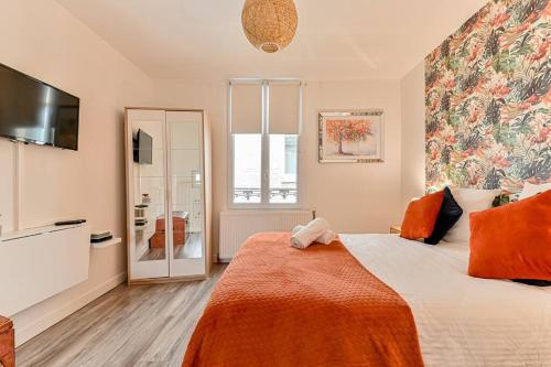 a bedroom with a bed with an orange blanket at Charmant duplex à deux pas de Paris et du RER B - parking gratuit in Gentilly
