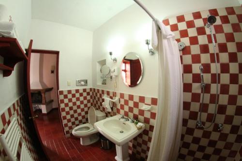 a bathroom with a sink and a toilet and a mirror at Hotel Boutique Posada La Basilica in Pátzcuaro