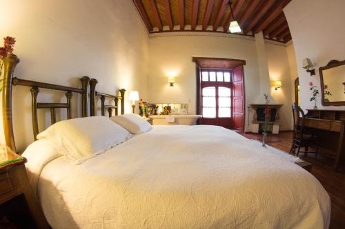 a bedroom with a large white bed in a room at Hotel Boutique Posada La Basilica in Pátzcuaro