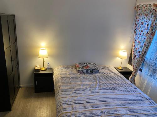 a bedroom with a bed and two lamps on two tables at apartment close to La Defense in Nanterre