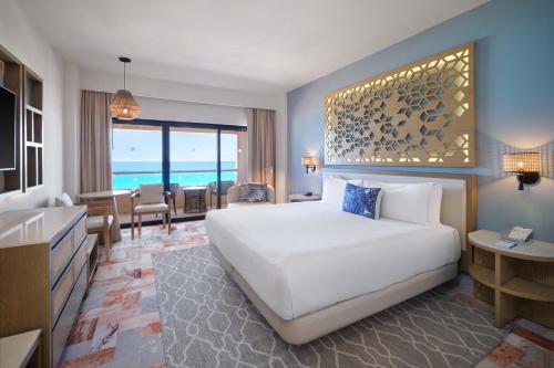a hotel room with a bed and a living room at Wyndham Grand Cancun All Inclusive Resort & Villas in Cancún