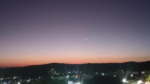 uma lua no céu sobre uma cidade à noite em Apartamento para até 4 pessoas em Garanhuns-PE em Garanhuns
