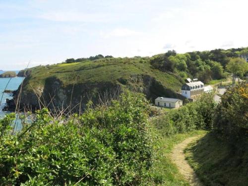 a house on a hill next to the ocean at Appart vue mer-au pied du chemin de randonnée " Bassan" in Planguenoual