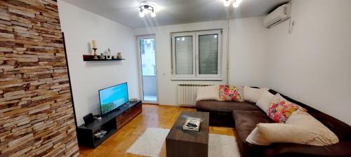 sala de estar con sofá y TV en Lux Apartment Rose 2 60m2, en Kragujevac