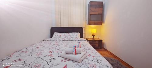 a bedroom with a bed with towels and candles on it at Lux Apartment Rose 2 60m2 in Kragujevac