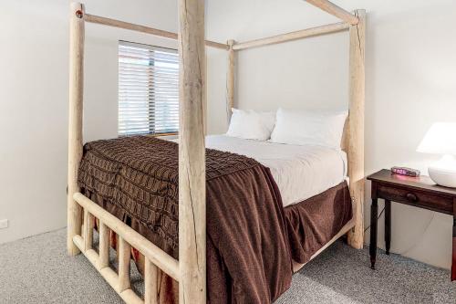 um quarto com uma cama de dossel em madeira em Silver Star Retreat em Ponderosa Fairway Estates
