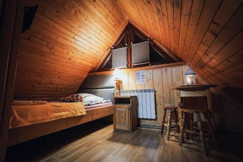 ザコパネにあるPokoje Goscinne Majerczykの木造キャビン内のベッド1台が備わるベッドルーム1室を利用します。