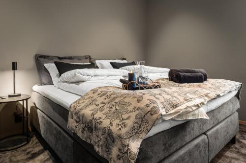 ein großes Bett mit einer Decke darüber in der Unterkunft Toppleilighet på bryggen i Sogndal med fantastisk utsikt in Sogndal