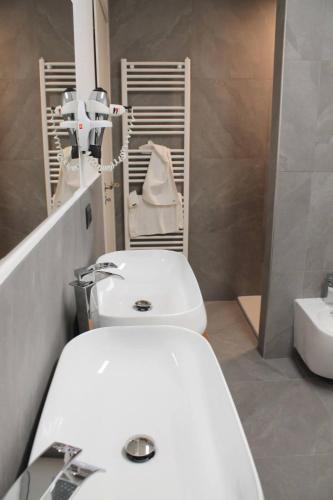 a bathroom with a white toilet and a sink at Hotel Carlone in Breguzzo