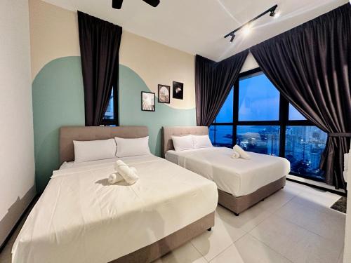 two beds in a room with large windows at Urban Suite Cozy Family Homestay at Georgetown by URBAN STAYCATION HENG LOD in Jelutong