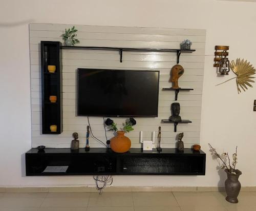 ein Wohnzimmer mit einem TV an der Wand in der Unterkunft Sylvadore'Appart in Cotonou