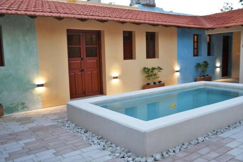 a swimming pool in front of a house at Trilliza Amarilla in Campeche