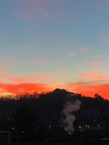 a sunset with smoke coming out of a train at Cloos - Elegant Residence with Panoramic View in Braşov