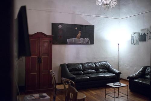 a living room with a leather couch and a table at Hotel Gertrudis in Morelia