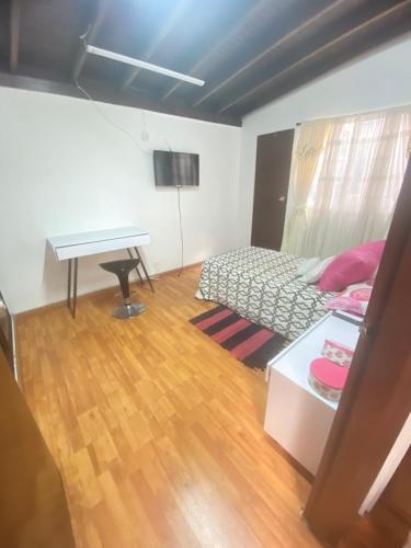 - une chambre avec un lit, un bureau et un piano dans l'établissement Habitación para viajero, à Pasto
