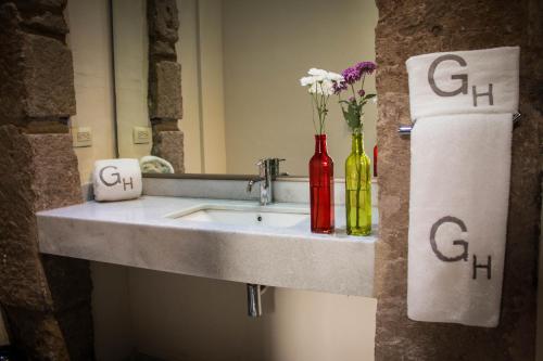 a bathroom sink with two bottles and a towel at Hotel Gertrudis in Morelia