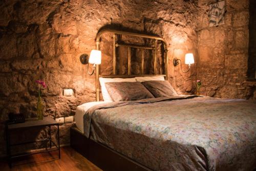 a bedroom with a bed in a stone wall at Hotel Gertrudis in Morelia