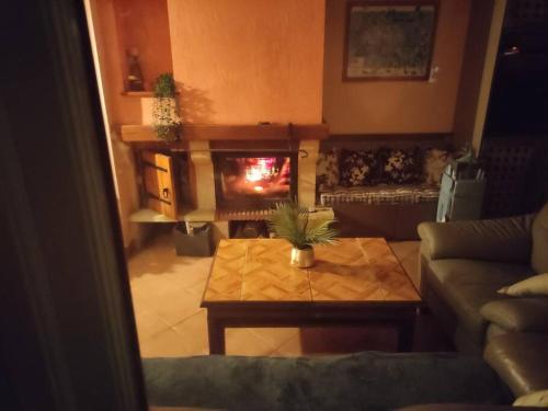 a living room with a table and a fireplace at LA PETITE GRANGE in Fresnes-Tilloloy