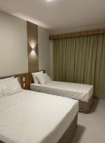 ein Hotelzimmer mit 2 Betten in einem Zimmer in der Unterkunft Prive Praias do Lago Ecoresort in Caldas Novas