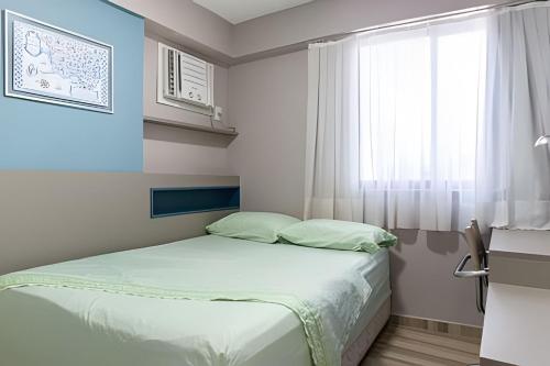 een kleine slaapkamer met een bed en een raam bij Flat 1 Quarto Jaqueira Recife - Wi-fi e Garagem in Recife