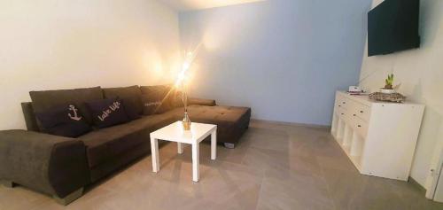 ein Wohnzimmer mit einem Sofa und einem Tisch in der Unterkunft Apartment 10 Palmen Locarno in Locarno