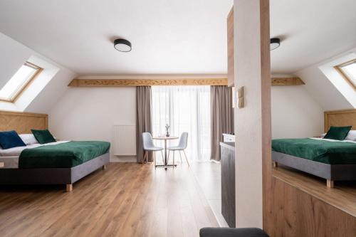 una habitación de hotel con dos camas y una mesa en Ornak 7, en Zakopane