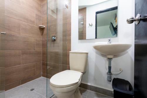 a bathroom with a toilet and a sink and a shower at Hotel De León Estadio in Medellín