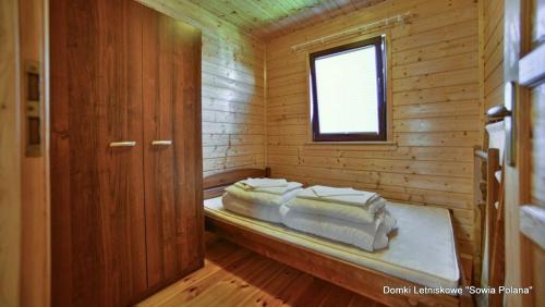 a room with two beds in a wooden cabin at Wunderschönes Ferienhaus in Bobolin mit Grill und Terrasse in Bobolin