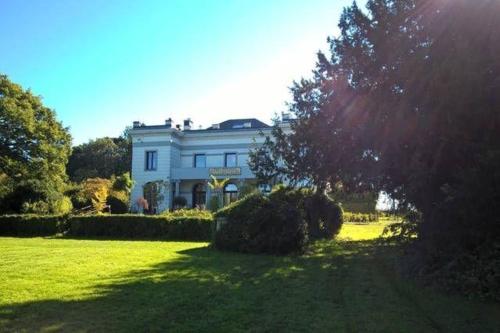 una gran casa blanca en un césped verde en Ferienhaus für 8 Personen ca 300 qm in Couvin, Wallonie Provinz Namur, en Couvin