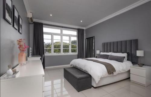 een slaapkamer met een groot bed en een raam bij The Views BNB in Durban