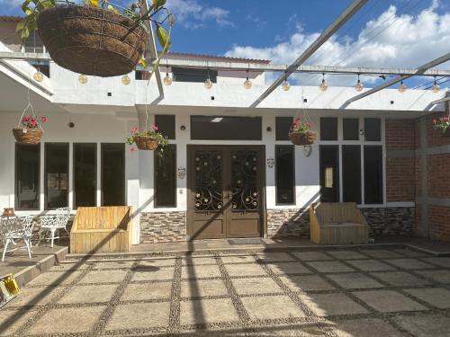 ein Gebäude mit einer Terrasse mit Stühlen und einer Tür in der Unterkunft La casa de luz in Concepción de Ataco