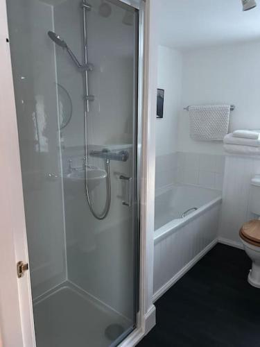 a shower with a glass door in a bathroom at Fairness Cottage, Near Comrie in Comrie