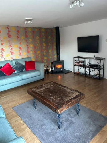 a living room with a couch and a coffee table at Fairness Cottage, Near Comrie in Comrie