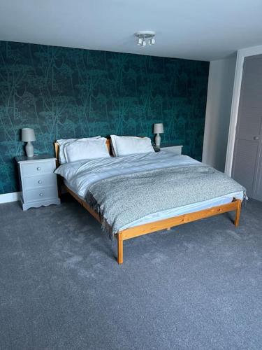 1 dormitorio con 1 cama con pared verde en Fairness Cottage, Near Comrie en Comrie