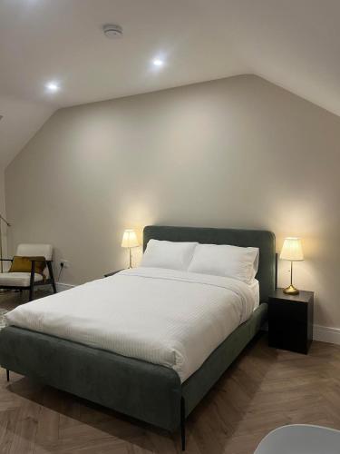 ein Schlafzimmer mit einem großen Bett mit weißer Bettwäsche in der Unterkunft Attic Room in Citywest in Dublin