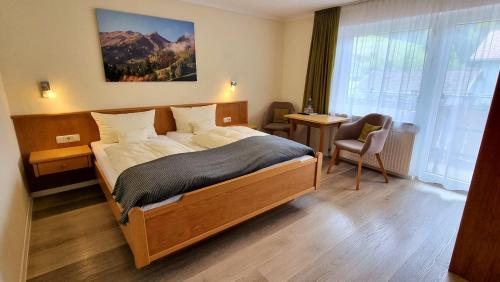 Schlafzimmer mit einem Bett, einem Schreibtisch und einem Fenster in der Unterkunft Haus Luise in Bad Hindelang