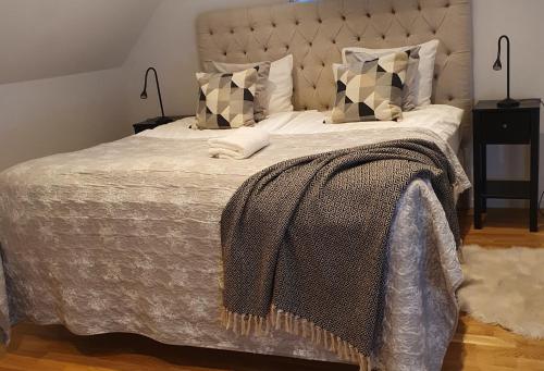 Three Bedroom Villa Segersjö في Tumba: سرير عليه بطانيه ومخدات