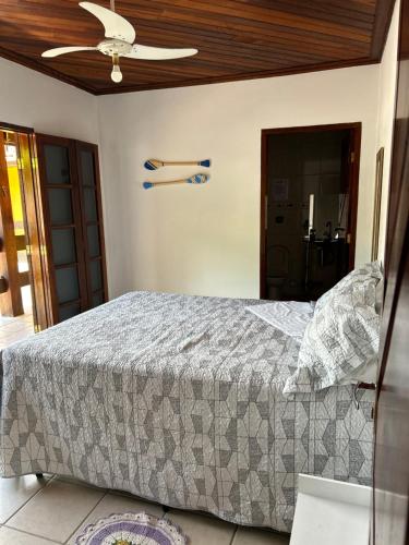 1 dormitorio con 1 cama y ventilador de techo en Casa da Si Suítes & Hostel, en Ubatuba